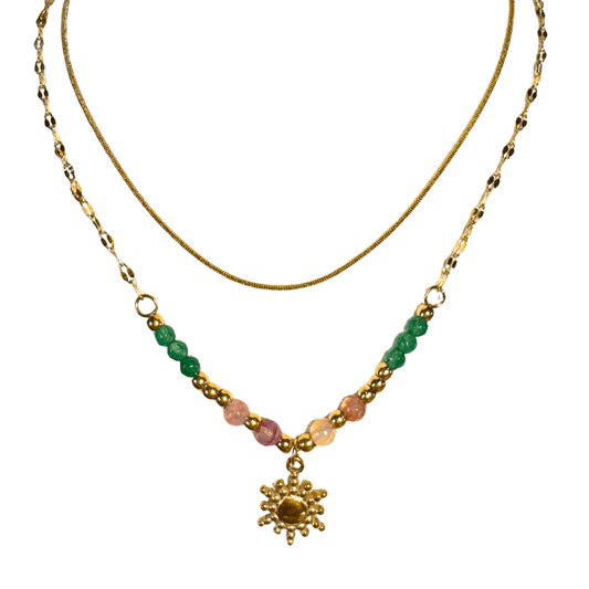 Gold necklace with green and pink beads and a gold flower pendant on a white background