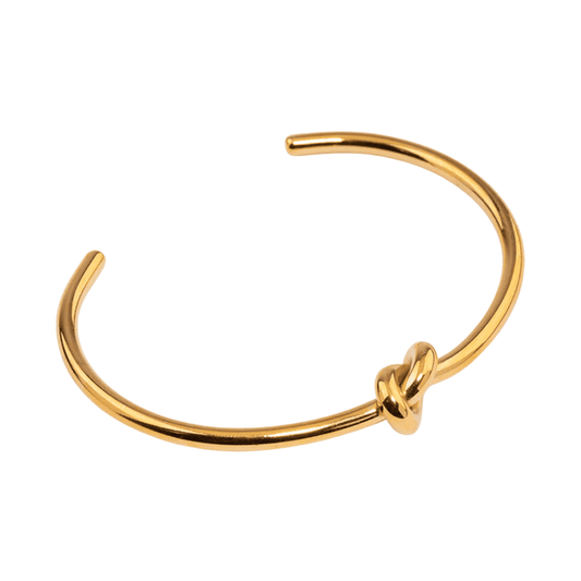 Gold bracelet with a knot design on a white background