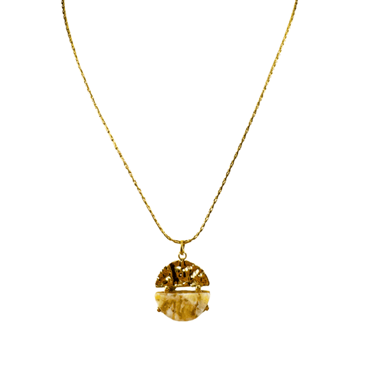 Gold necklace with a round pendant on a white background