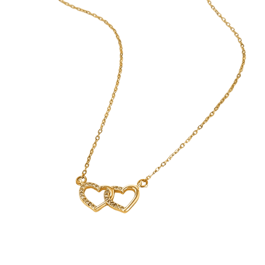 Gold necklace with a heart-shaped pendant on a white background