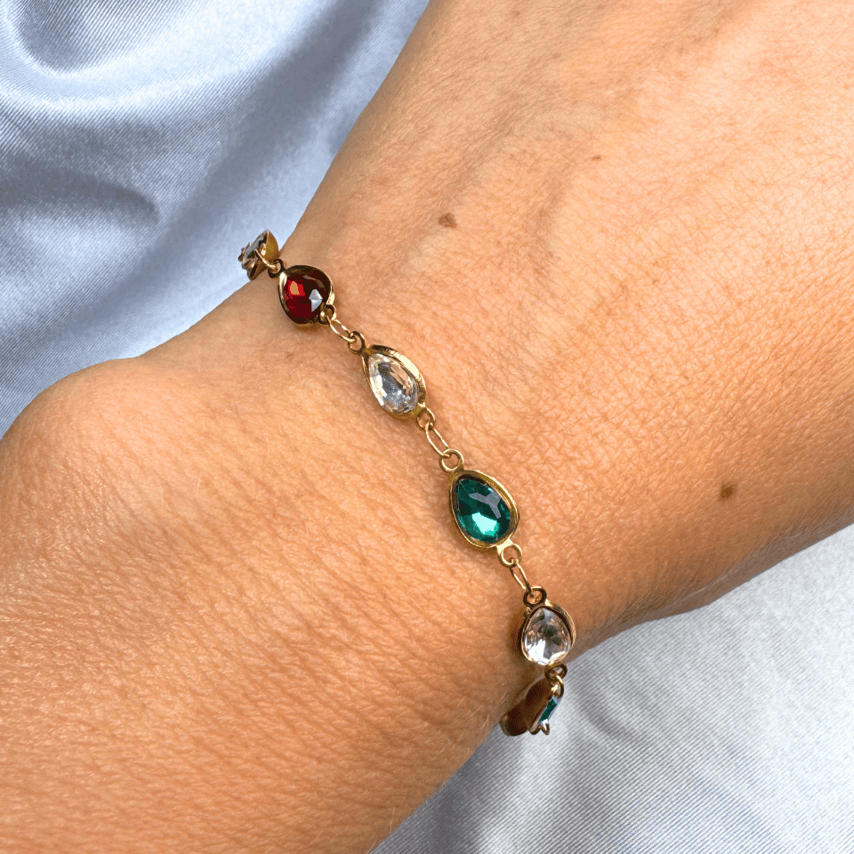 Bracelet with colorful gemstones on a wrist against a light background