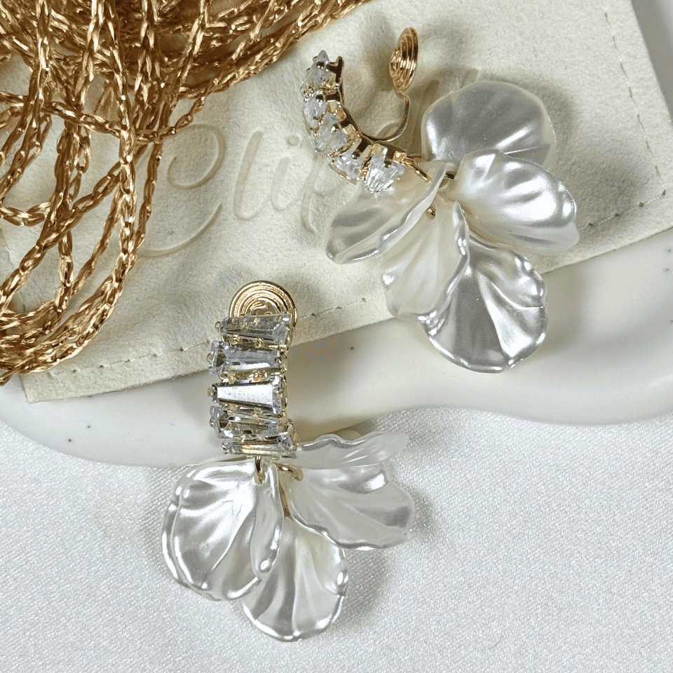 Silver floral earrings with gemstones on a white surface