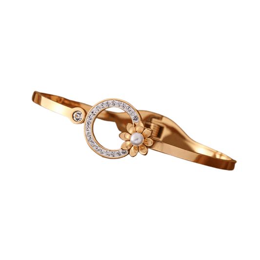 Gold bracelet with floral design and pearl on a white background