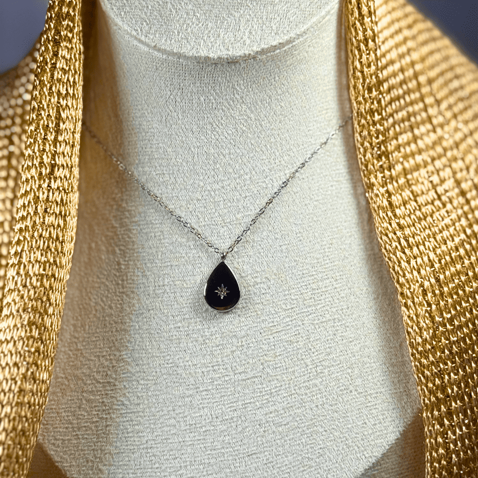 Necklace with a black teardrop pendant on a mannequin bust.