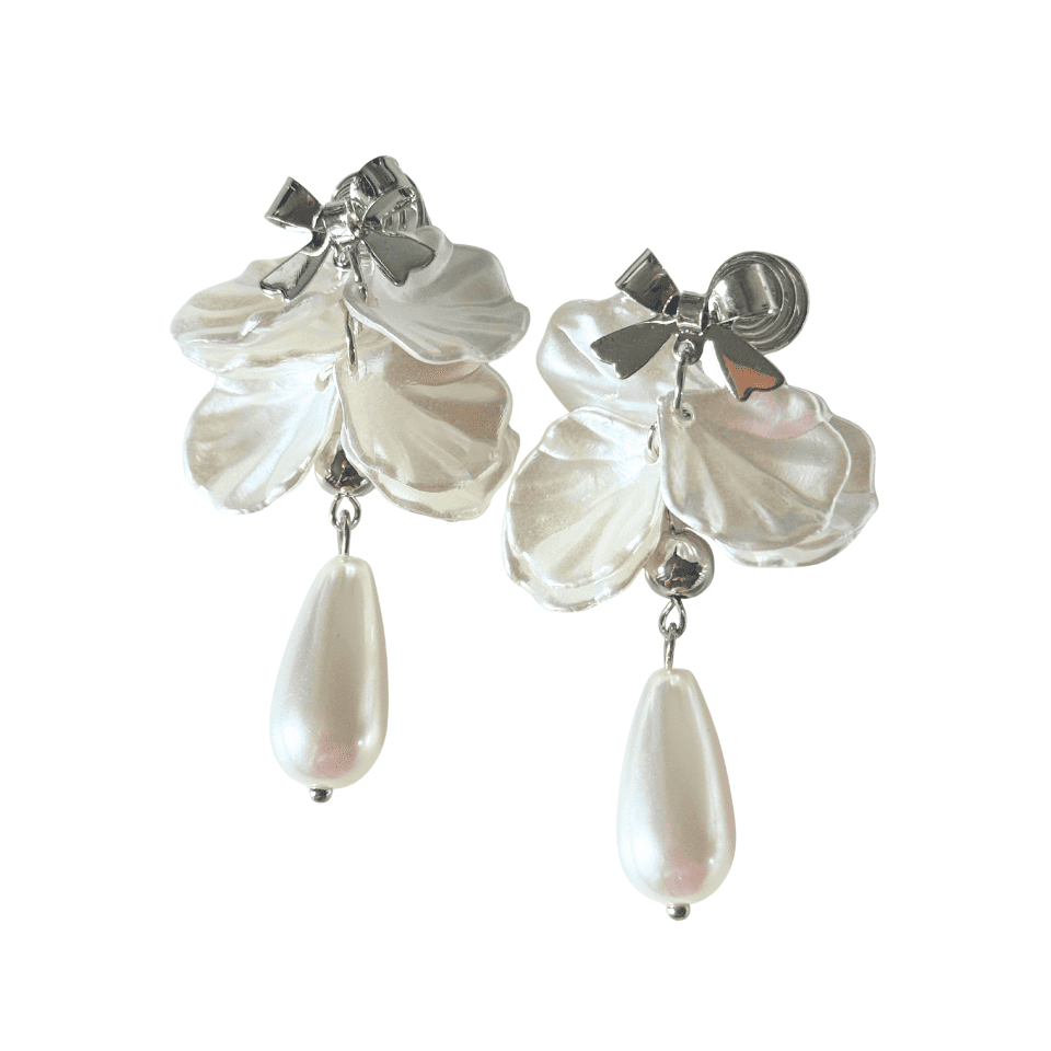 Pair of earrings with white floral petals and teardrop-shaped pearls on a white background
