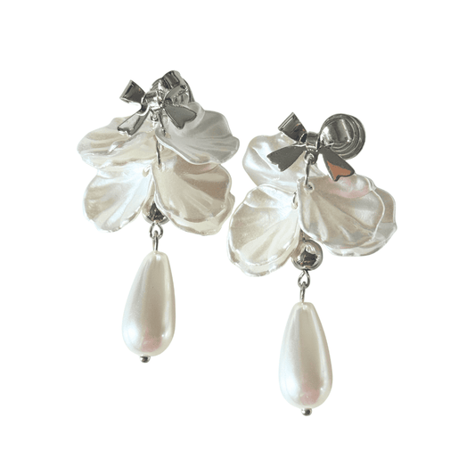 Pair of earrings with white floral petals and teardrop-shaped pearls on a white background