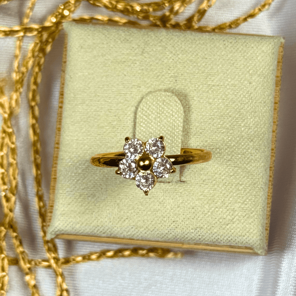 Gold ring with diamonds on a light green jewelry box