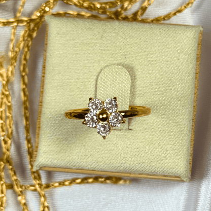 Gold ring with diamonds on a light green jewelry box